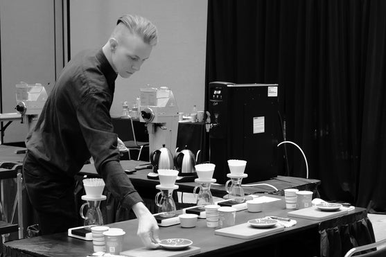 A barista competitor organising their set up.